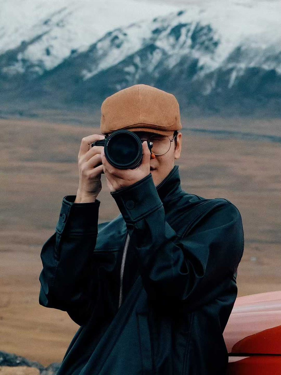 Hardy with camera in front of mountains