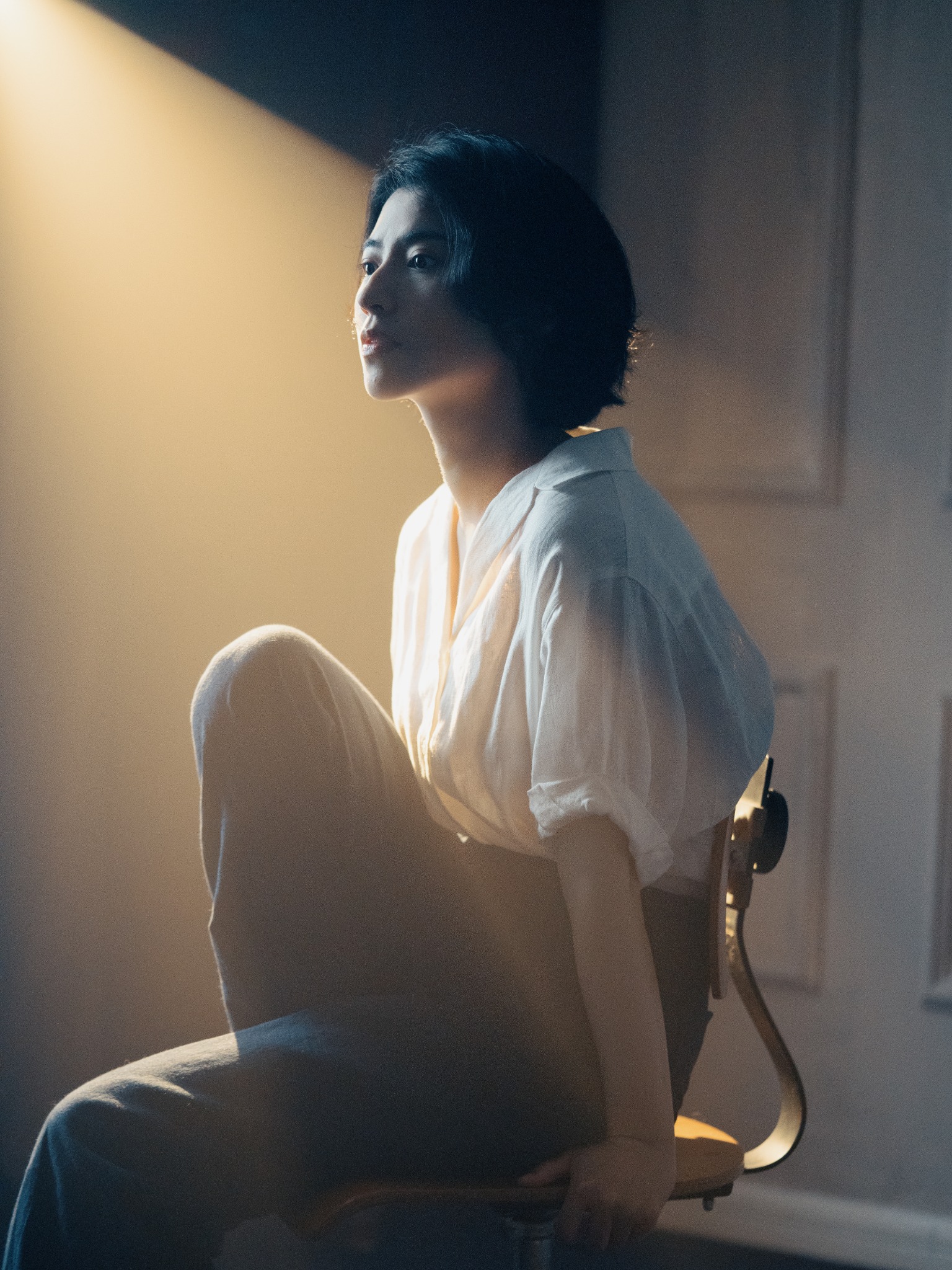 Moody seated portrait in a shaft of light